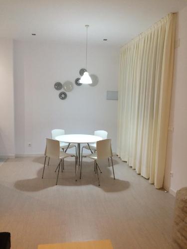 a dining room with a white table and chairs at Apartamentos La Estación M&S in Albacete