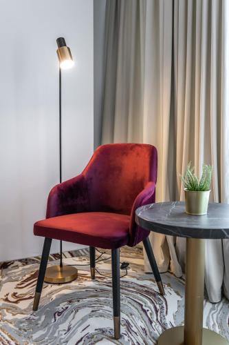 a red chair sitting next to a table at Ramada by Wyndham Bucharest Otopeni Airport in Otopeni