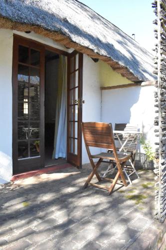 a wooden chair sitting on the porch of a house at Bramleigh Farm in Nottingham Road