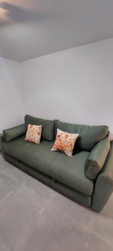 a green couch with three pillows sitting in a room at Villa Irene in Veli Lošinj