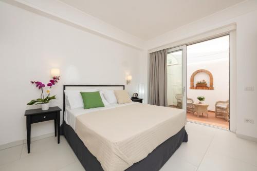 a white bedroom with a large bed and a balcony at Casa Giuliani Capri in Capri