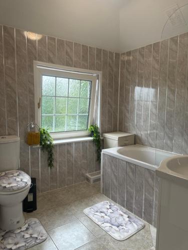 a bathroom with a tub and a toilet and a sink at Signet Luxury 3-bedrooms, 2bathrooms House with WiFi & Netflix in Rochester