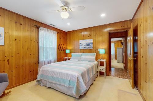 a bedroom with wooden walls and a large bed at Feeling Tip'Sea in Edisto Island