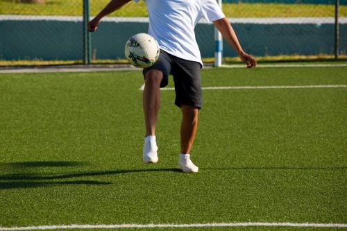 a man kicking a soccer ball on a field at Lixus Beach Resort - All In in Larache