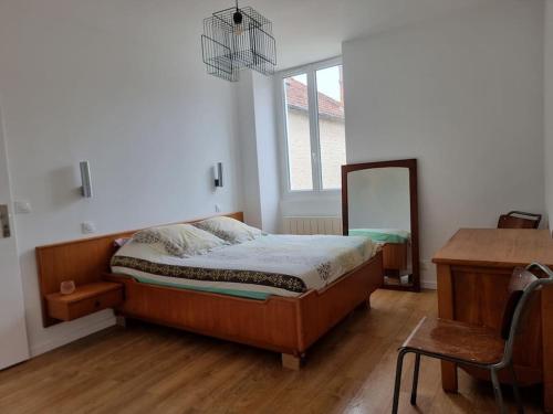 une chambre avec un lit, un bureau et un miroir dans l'établissement Maison de campagne, à Gironville-sur-Essonnes