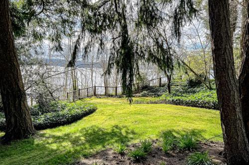 a field of grass with trees and a fence at Puget Sound Orca Retreat in Poulsbo