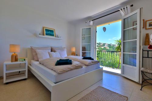 une chambre avec un grand lit et un balcon dans l'établissement Ferienhaus La Sauvageonne mit Whirlpool und grandiosem Meerblick, familienfreundlich, aux Issambres