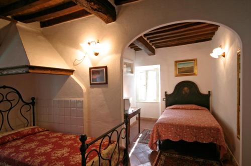 a bedroom with a bed in a room with an archway at La Corte di Ardengo in Civitella Marittima