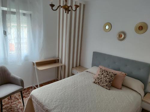 a bedroom with a bed and a chair and a clock at Apartamento's Montiño in O Grove