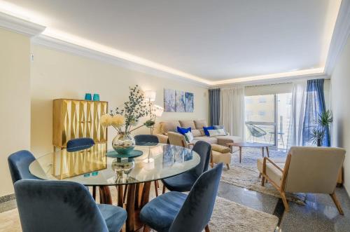 a living room with a table and chairs at Portugal Portfolio - Parede Beach Apartment in Parede