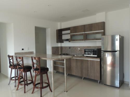 a kitchen with a counter and a refrigerator at Sea Colors Apartments in San Andrés