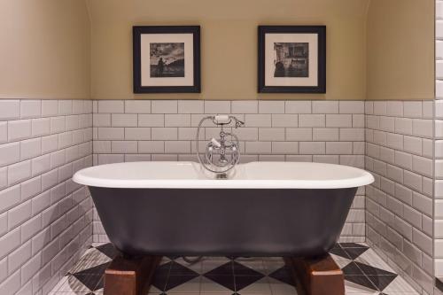 a bath tub in a bathroom with white tiles at Hotel Du Vin Edinburgh in Edinburgh