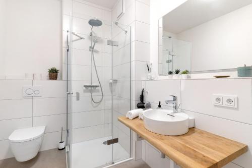 Un baño blanco con lavabo y ducha. en Km Style Apartments 6, en Freiburg im Breisgau