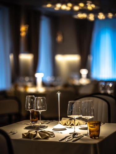 a table with wine glasses and silverware on it at Apeiro City Avant-garde Hotel in Sarajevo