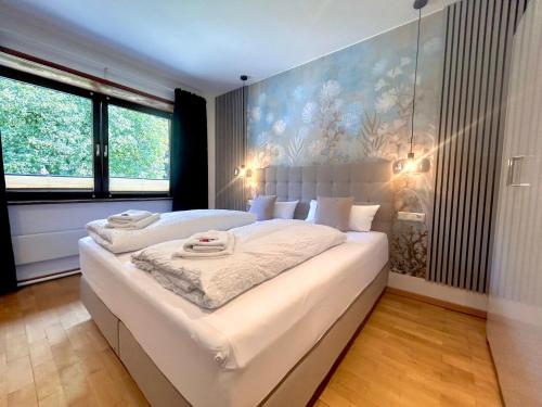 ein großes weißes Bett in einem Zimmer mit Fenstern in der Unterkunft Hotel garni Königslinde - Wandern, Radeln, Skifahren & Genießen in Bayrischzell