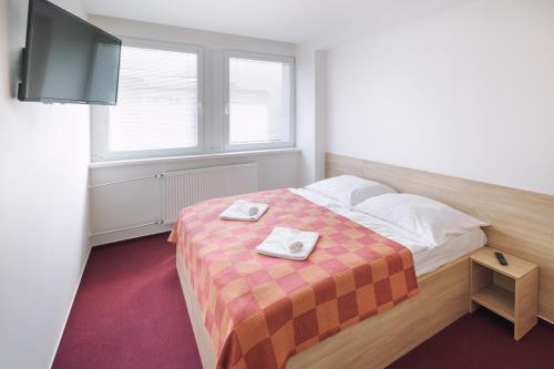 a bedroom with a bed with two towels on it at CITY HOTEL Družba in Liptovský Mikuláš