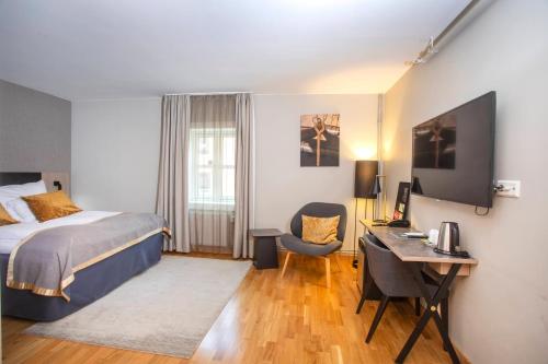 a hotel room with a bed and a desk and a desk at Home Hotel Bryggeparken in Skien
