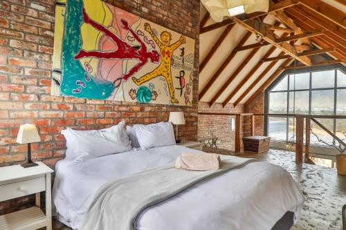 Un dormitorio con una cama grande en una pared de ladrillo. en Mountain View, en Bettyʼs Bay
