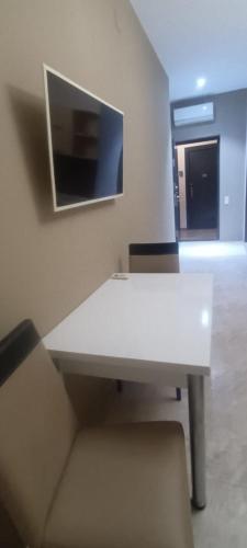 a white desk in a room with a tv on the wall at Schöne Wohnung mitten im Zentrum von Batumi in Batumi