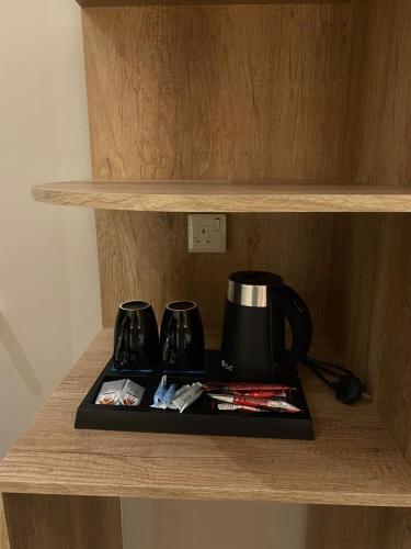 a coffee maker on a tray on a shelf at رامة المدينة للشقق المخدومة in Sīdī Ḩamzah