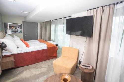 a hotel room with a bed and a flat screen tv at Home Hotel Bryggeparken in Skien
