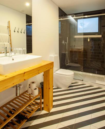a bathroom with a sink and a toilet and a shower at Casa Vela Boutique House in Cascais
