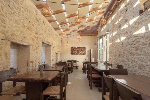 a restaurant with wooden tables and chairs and brick walls at Manili Boutique Suites & Villas in Archanes