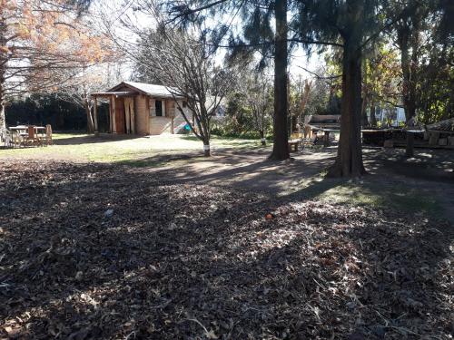 Un parque con árboles y una cabaña al fondo. en El ranchito, en Santa Coloma