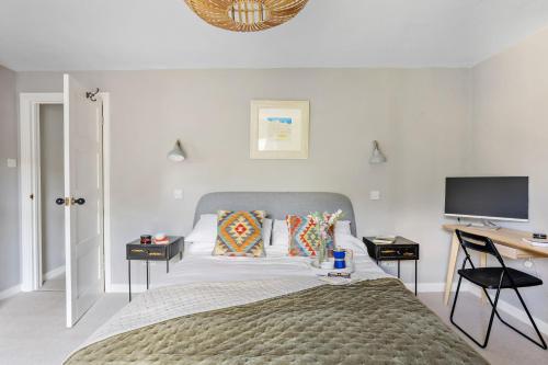 a bedroom with a bed and a desk and a television at The Old Shop House in Galmpton-on-the-Dart