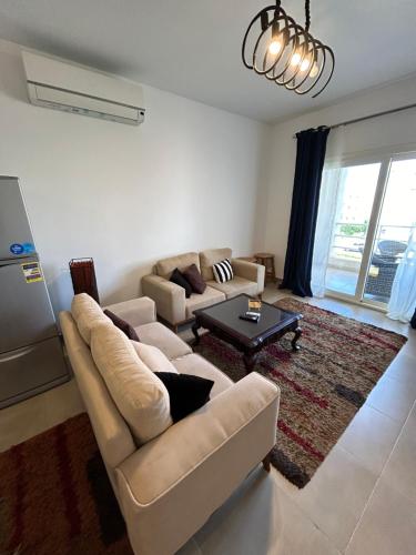 a living room with a couch and a table at امواج شاليه فندقي Amwaj north coast 2 bedroom in El Alamein