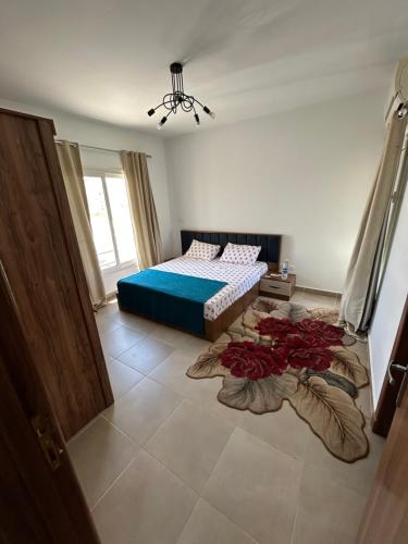 a bedroom with a bed and some red flowers on the floor at امواج شاليه فندقي Amwaj north coast 2 bedroom in El Alamein