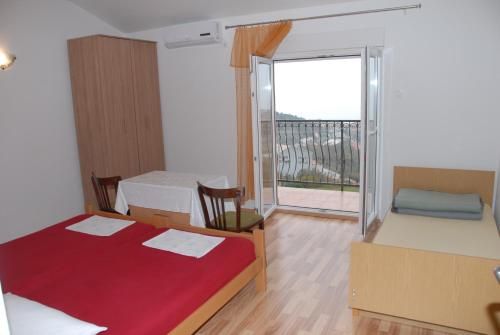 a room with two beds and a window with a balcony at Apartments Kate in Senj