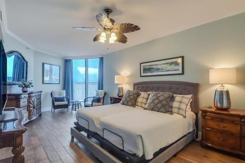a bedroom with a bed and a ceiling fan at Sandy Shores Condominium in Biloxi