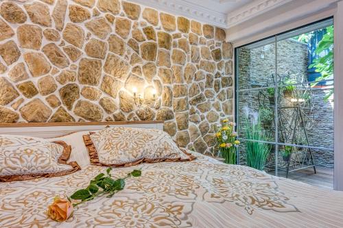a bedroom with a stone wall and a bed at Royal Garden in Škofja Loka
