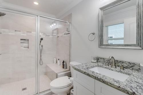 um banheiro com chuveiro, vaso sanitário e pia em The Swamp Rose Cottage em Bay Saint Louis