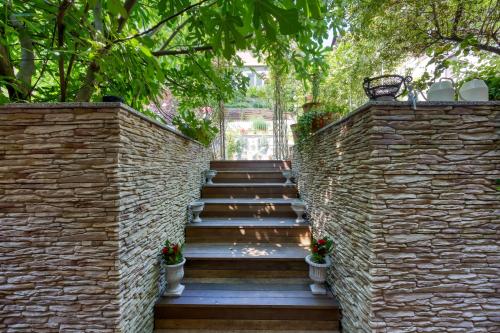 a stone wall with a staircase with potted plants at Royal Garden in Škofja Loka