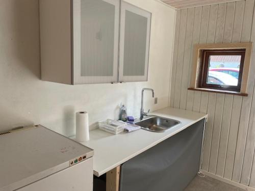 a kitchen counter with a sink and a window at Mygdal Hus in Mygdal