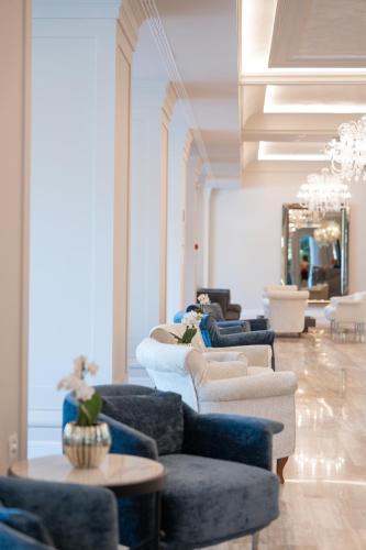 a living room with couches and chairs and a chandelier at Grand Hotel Gallia in Milano Marittima