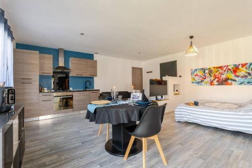 une cuisine et un salon avec une table et un lit dans l'établissement Suit Dream Bleue, à Les Mées