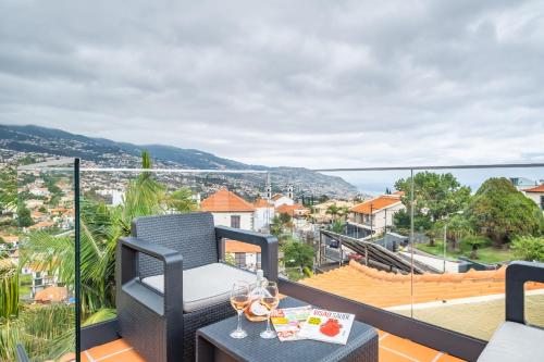 a balcony with a table with wine glasses on it at Eyes in the Sky in Funchal