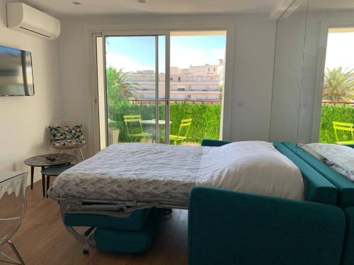 une chambre avec un lit et un balcon avec des chaises dans l'établissement Two bedroom apartment Rouaze, à Cannes
