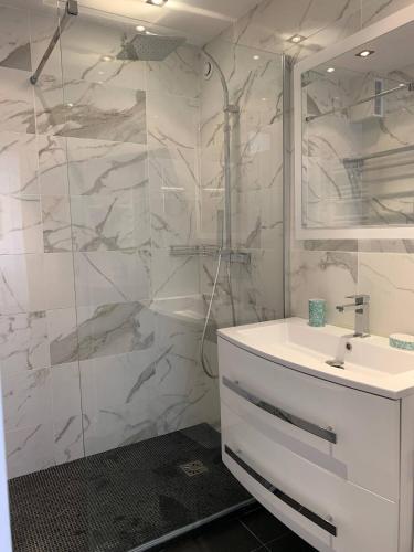 une salle de bain blanche avec un lavabo et une douche dans l'établissement Two bedroom apartment Rouaze, à Cannes
