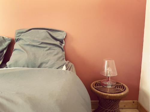 - un lit avec un oreiller et une lampe sur une table dans l'établissement Maison au milieu des chevaux, à LʼIsle-sur-la-Sorgue