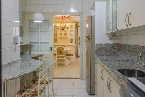 une cuisine avec des comptoirs en granit et une salle à manger dans l'établissement Elegância Clássica a 1 quadra da praia em Bc N704, à Balneário Camboriú