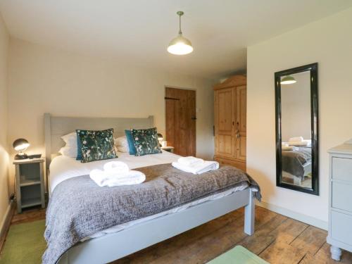 a bedroom with a bed with two towels on it at Shoemakers Cottage, Friston in Friston