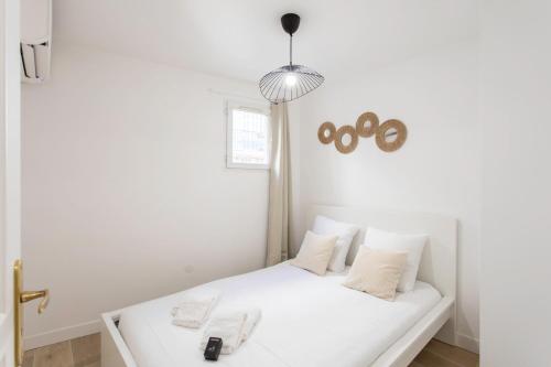 - une chambre blanche avec un lit blanc et des oreillers blancs dans l'établissement #58 Logement Clim & Balcon 5mins marche de la Mer, à Nice