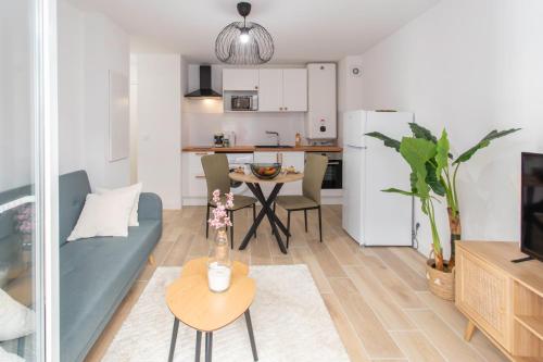 un salon avec un canapé et une table et une cuisine dans l'établissement #58 Logement Clim & Balcon 5mins marche de la Mer, à Nice