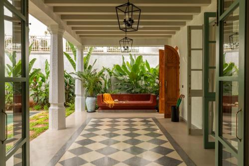 an indoor porch with a bench and plants at La Rozalia, Exquisite 4 BHK Villas with Large Pool, Garden, Dedicated Caretaker, Terrace, 2 mins from the famous Dear Zindagi Road in Mapusa