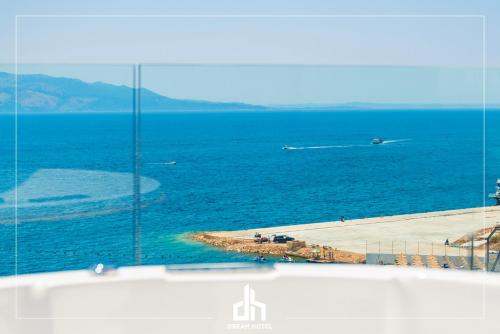 a view of the ocean through a glass window at DREAM HOTEL SARANDA in Sarandë