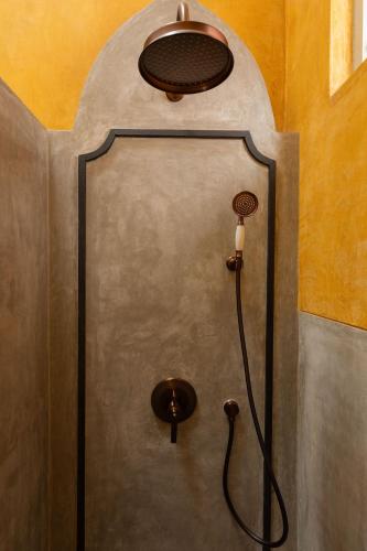 a shower in a bathroom with a shower head at La Rozalia, Exquisite 4 BHK Villas with Large Pool, Garden, Dedicated Caretaker, Terrace, 2 mins from the famous Dear Zindagi Road in Mapusa